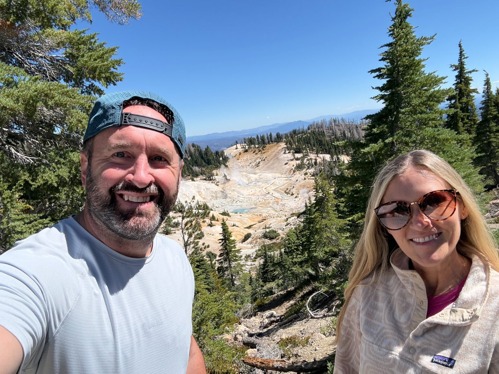 Tony and Trisha above the Bumpass Hell basin, the pale steaming ground and the boardwalk visible far below them