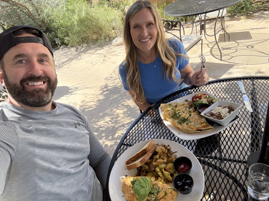 Tony and Trisha at a shaded patio table at Tohono Chul, a quesadilla and an egg plate between them